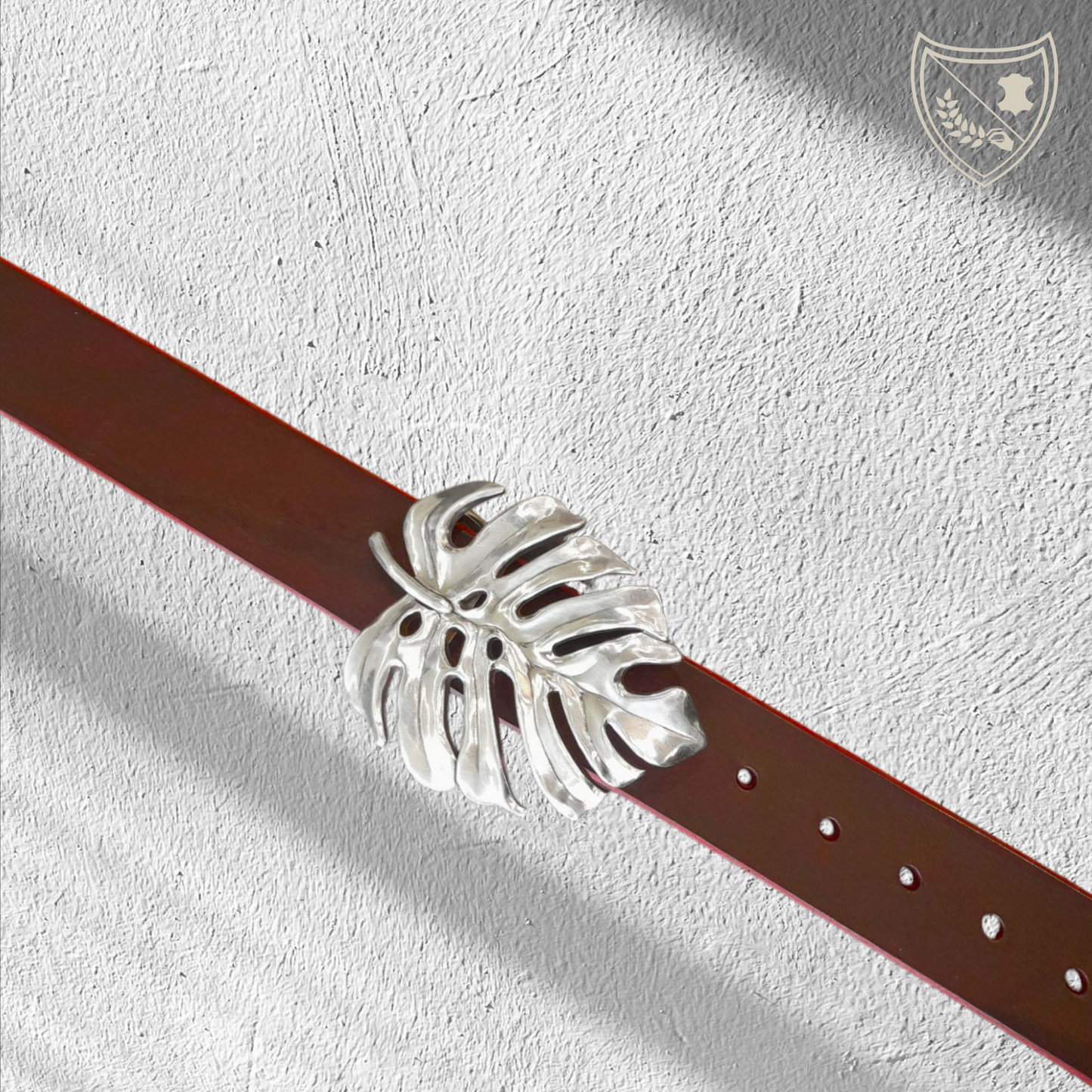 Ceinture cuir végétal de couleur victoria avec boucle de ceinture Monstera en métal argenté, feuille ajourée au design organique, élégante et affirmée, fermoir fiable pour confort et maintien.