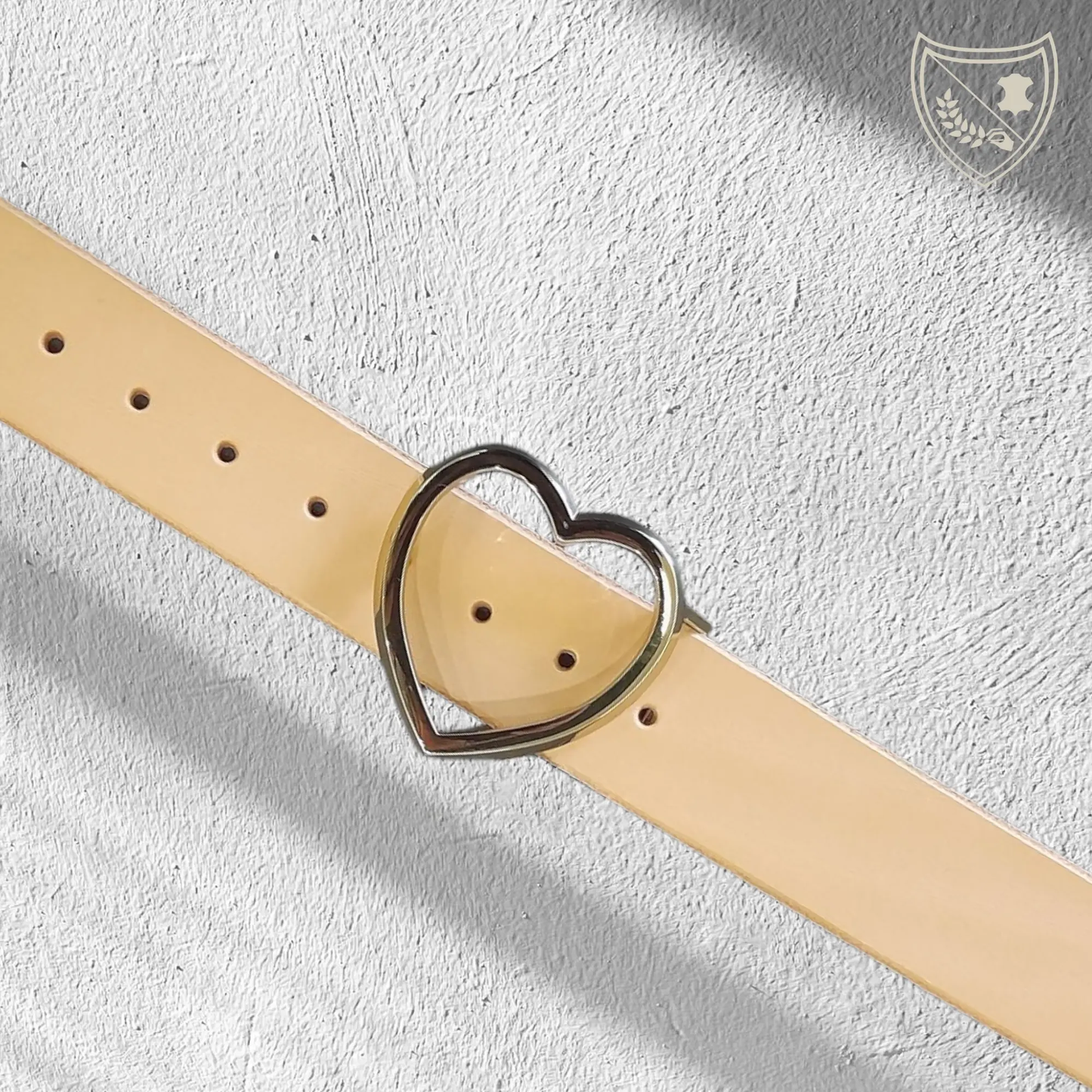 Ceinture cuir végétal couleur naturelle avec boucle de ceinture Golden Love en métal doré, cœur épuré et lumineux, pièce délicate mais affirmée, fermoir fiable pour confort et maintien du quotidien aux moments d’exception