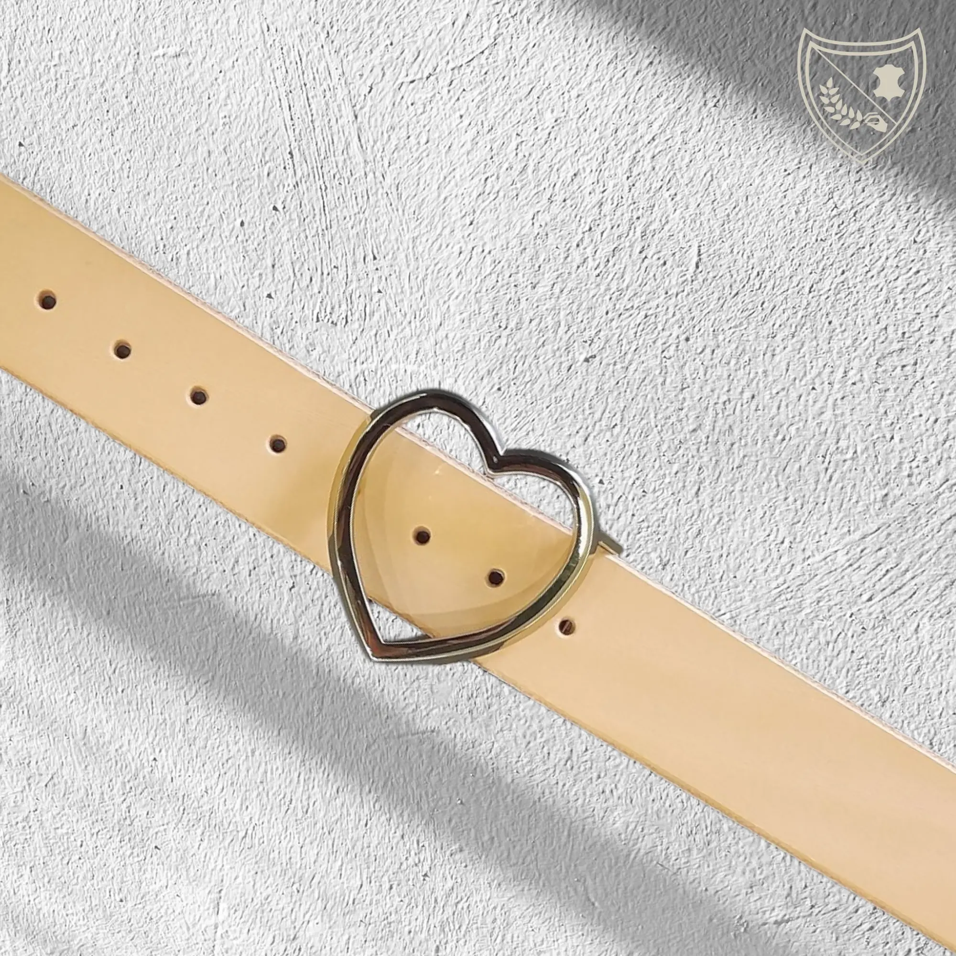 Ceinture cuir végétal couleur naturelle avec boucle de ceinture Golden Love en métal doré, cœur épuré et lumineux, pièce délicate mais affirmée, fermoir fiable pour confort et maintien du quotidien aux moments d’exception