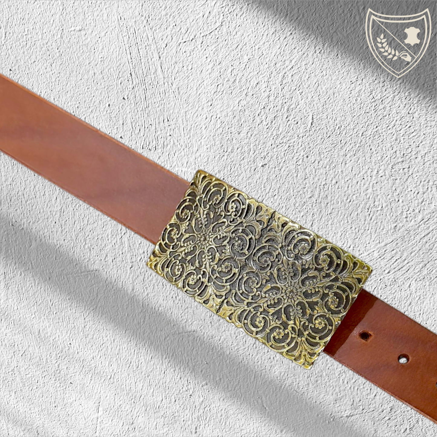 Ceinture cuir tannage végétal couleur havana avec boucle de ceinture à arabesques florales en relief, profondeur somptueuse aux reflets captivants, charme oriental intemporel, fermoir fiable pour confort et maintien. 