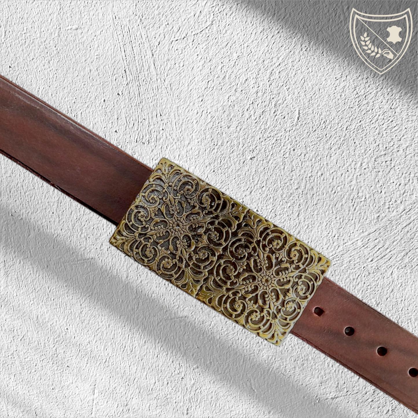 Ceinture cuir tannage végétal couleur chocolat avec boucle de ceinture à arabesques florales en relief, profondeur somptueuse aux reflets captivants, charme oriental intemporel, fermoir fiable pour confort et maintien. Vue de face