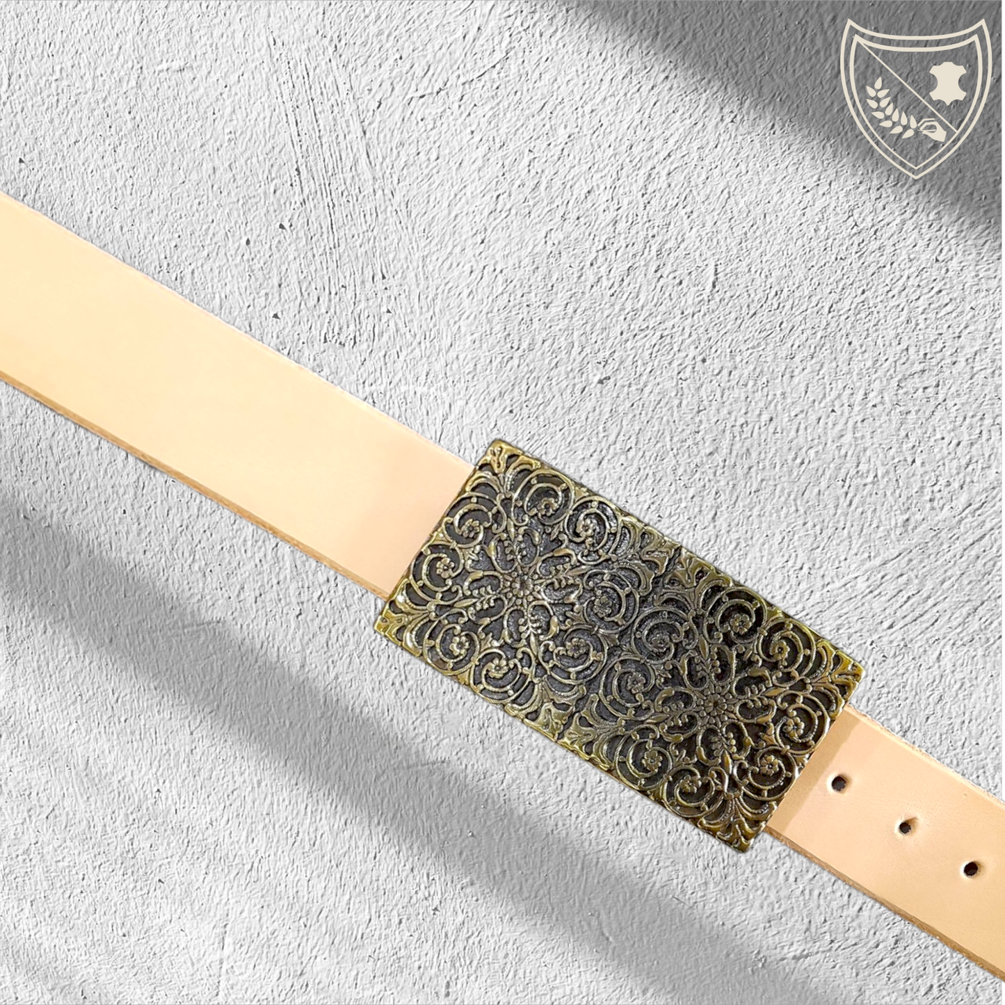 Ceinture cuir tannage végétal couleur naturelle avec boucle de ceinture à arabesques florales en relief, profondeur somptueuse aux reflets captivants, charme oriental intemporel, fermoir fiable pour confort et maintien. 