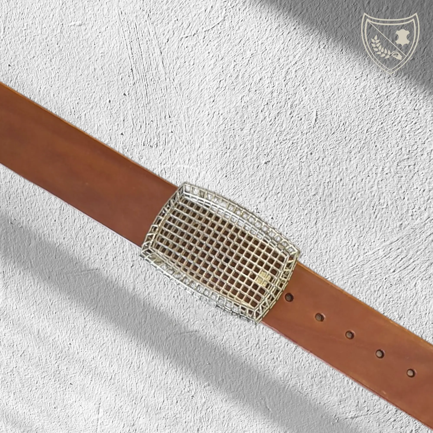 Ceinture cuir tannage végétal couleur havana avec boucle de ceinture Square, design ajouré en quadrillage, esthétique légère et architecturale, métal robuste, fermoir fiable pour confort et maintien du bureau au week‑end. Vue de face