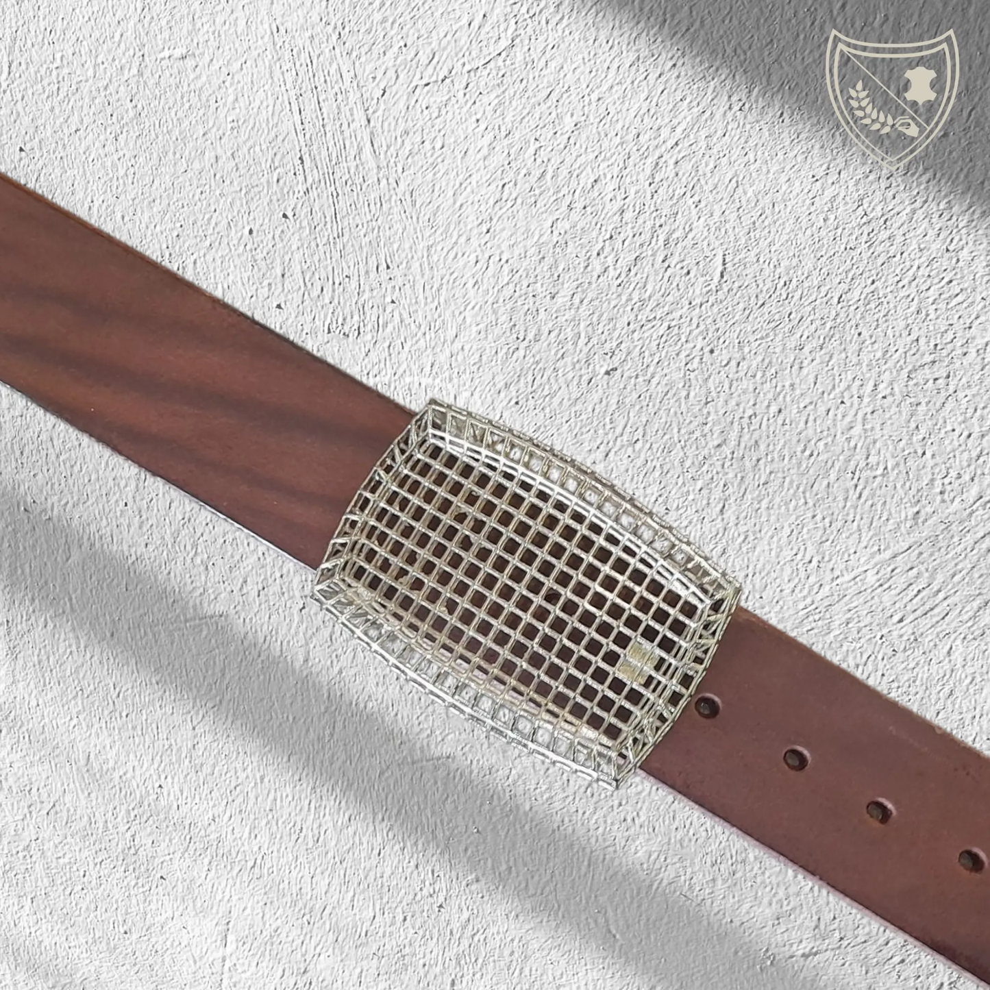 Ceinture cuir tannage végétal couleur chocolat avec boucle de ceinture Square, design ajouré en quadrillage, esthétique légère et architecturale, métal robuste, fermoir fiable pour confort et maintien du bureau au week‑end. Vue de face