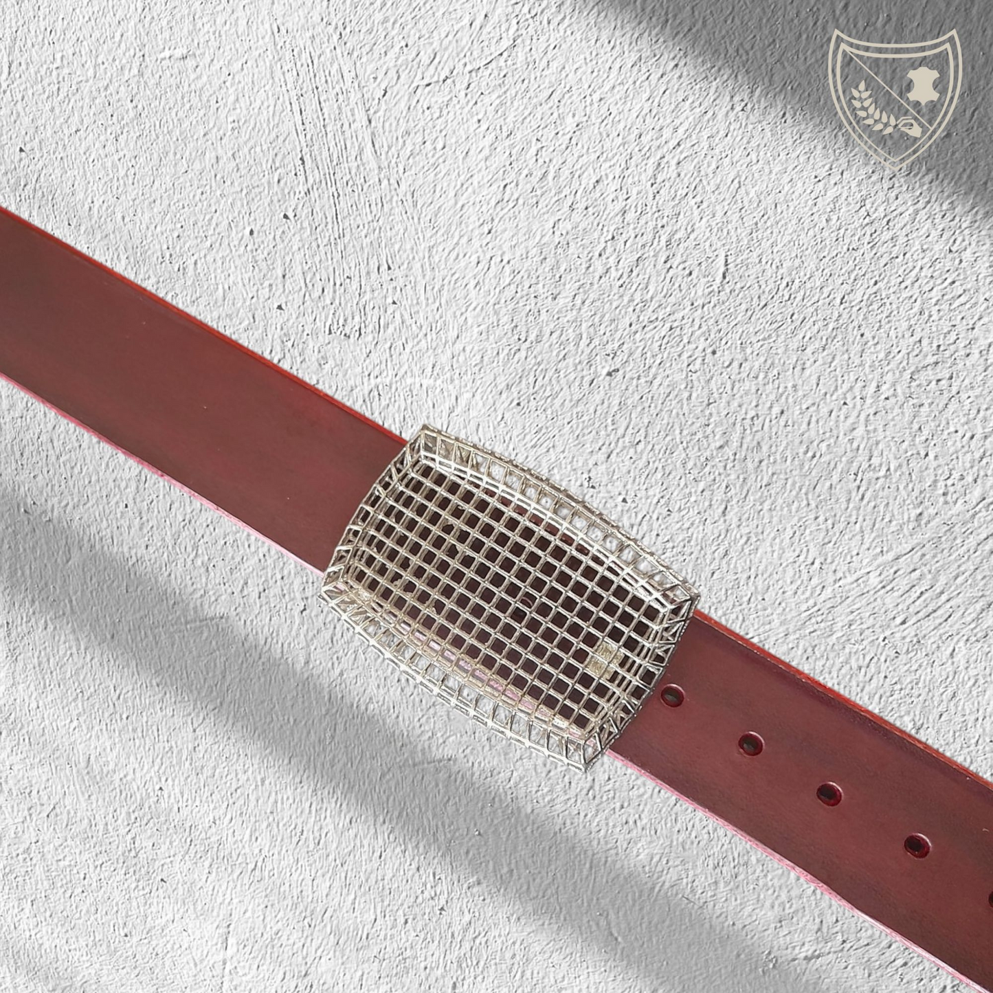 Ceinture cuir tannage végétal couleur victoria avec boucle de ceinture Square, design ajouré en quadrillage, esthétique légère et architecturale, métal robuste, fermoir fiable pour confort et maintien du bureau au week‑end. Vue de face