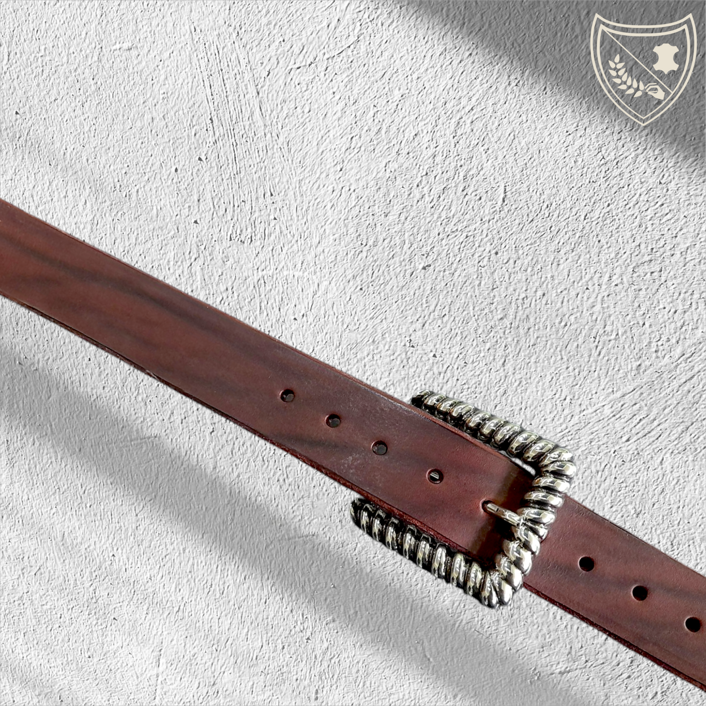 Ceinture cuir tannage végétal couleur chocolat avec boucle de ceinture Twist en métal argenté, contour torsadé en spirale, jeux de lumière pour allure sculpturale, élégance moderne et intemporelle, fermoir fiable pour confort et maintien.