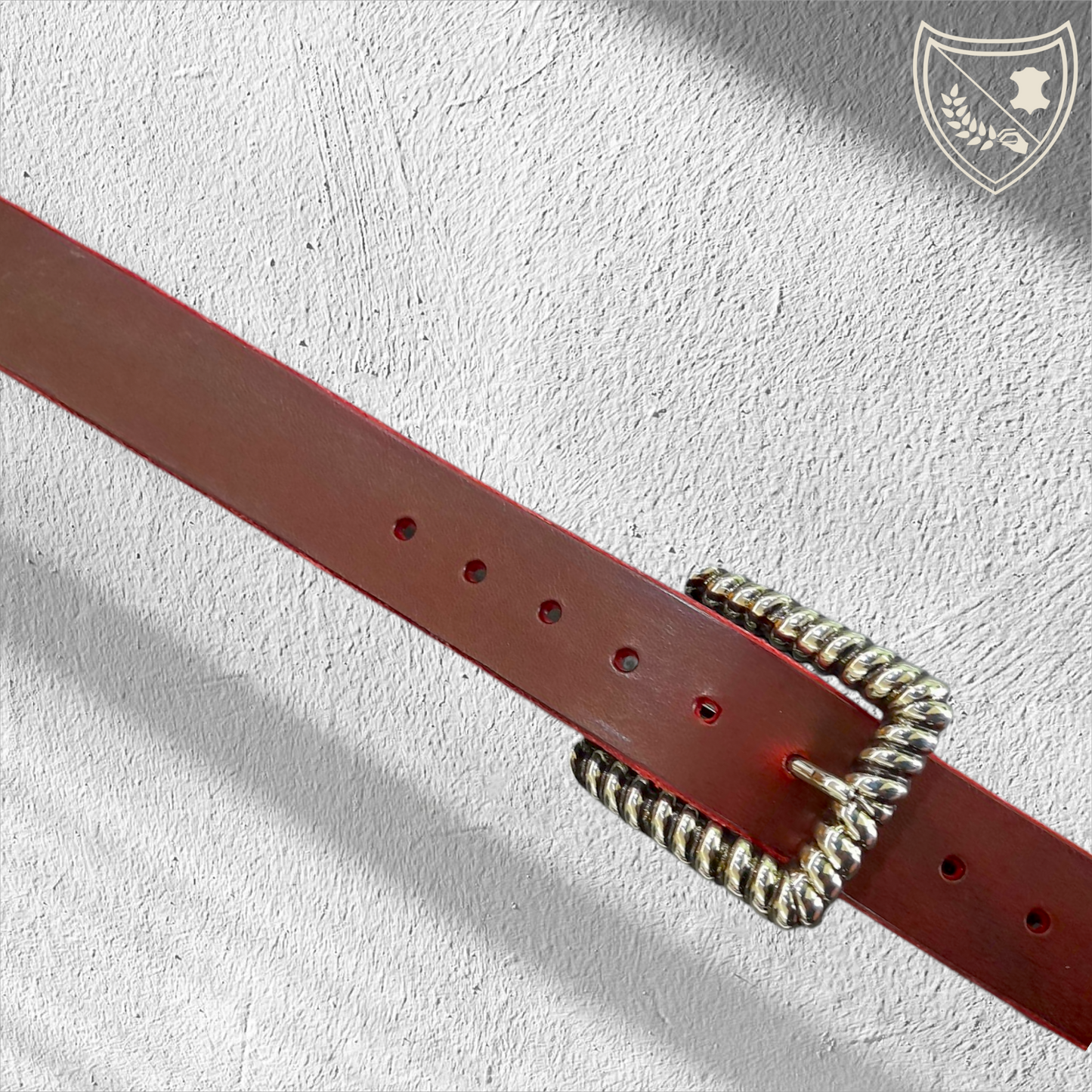 Ceinture cuir tannage végétal couleur victoria avec boucle de ceinture Twist en métal argenté, contour torsadé en spirale, jeux de lumière pour allure sculpturale, élégance moderne et intemporelle, fermoir fiable pour confort et maintien.