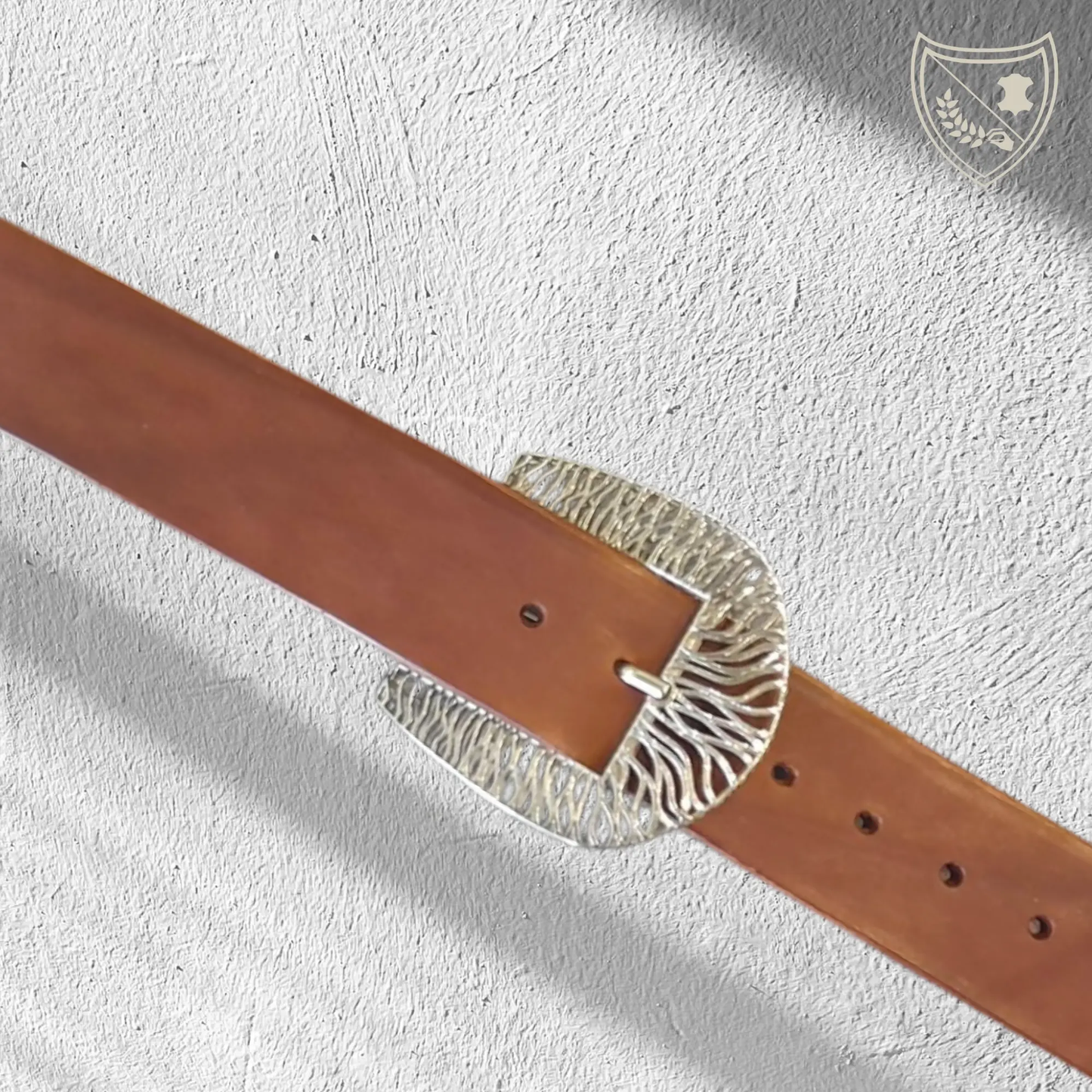 Ceinture cuir végétal de couleur havana avec boucle de ceinture Tigre en métal argenté, lignes fluides pour allure puissante et raffinée, audacieuse mais chic, fermoir fiable pour confort et maintien du quotidien aux occasions habillées. Vue de face