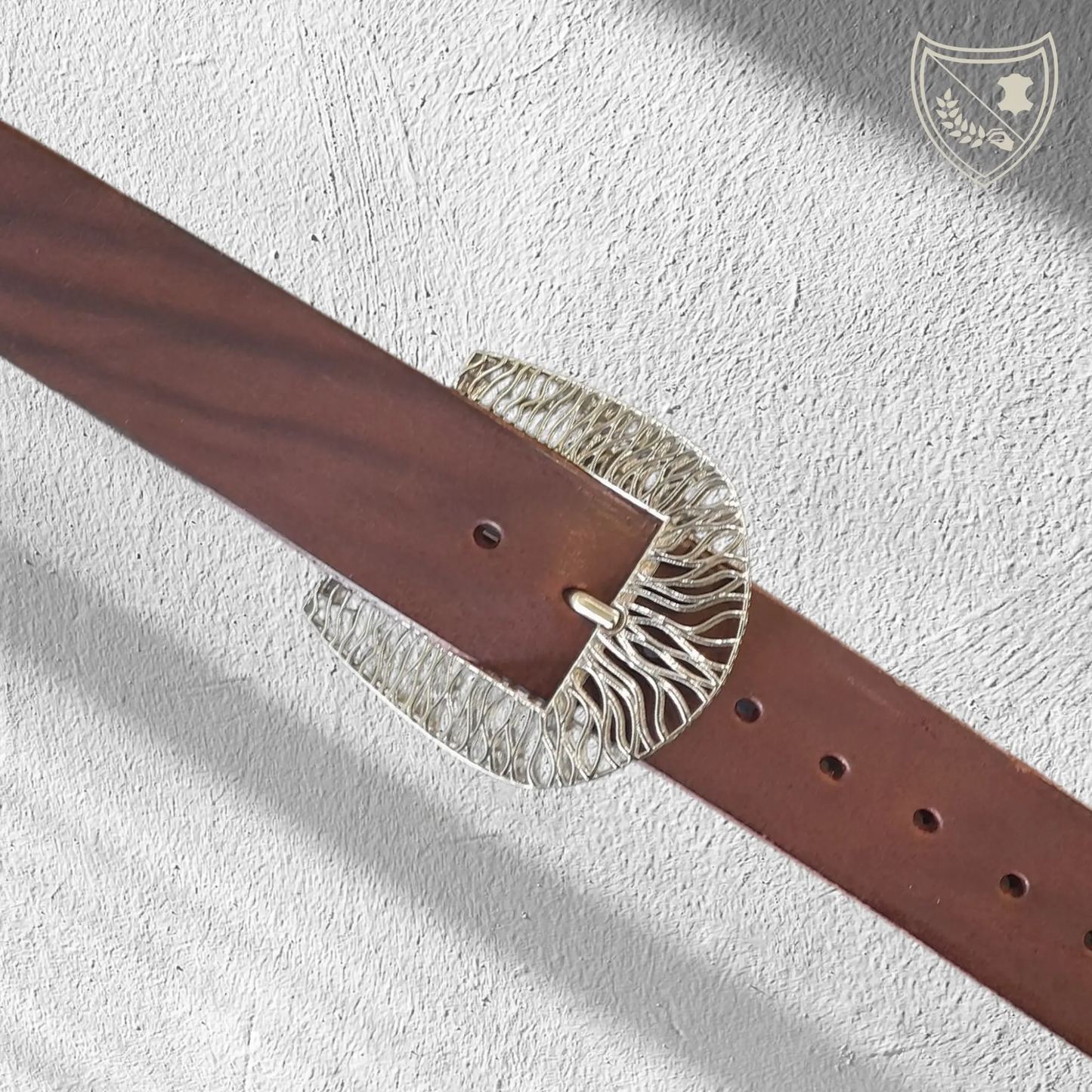 Ceinture cuir végétal de couleur chocolat avec boucle de ceinture Tigre en métal argenté, lignes fluides pour allure puissante et raffinée, audacieuse mais chic, fermoir fiable pour confort et maintien du quotidien aux occasions habillées. Vue de face