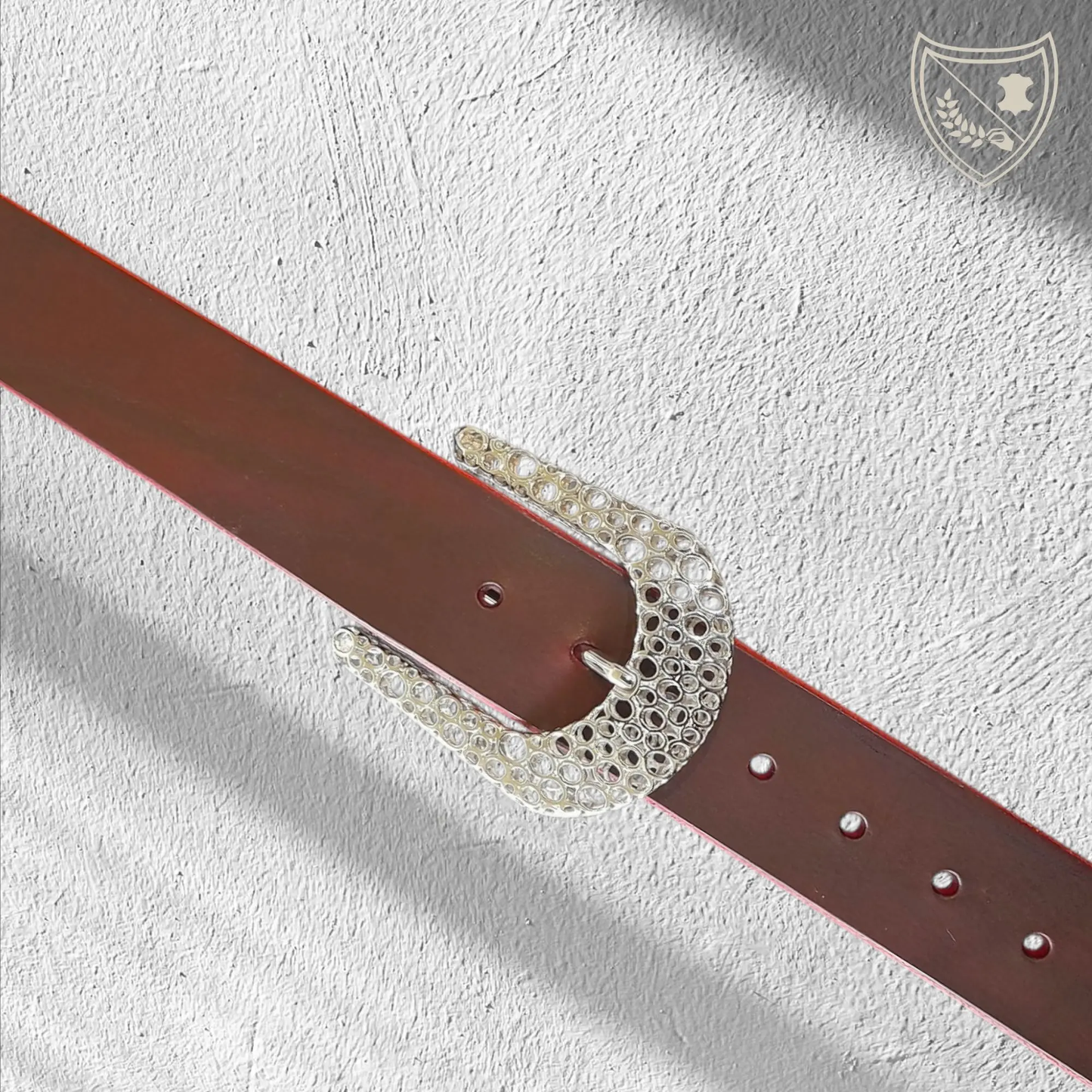 Ceinture cuir tannage végétal couleur victoria avec boucle de ceinture Guépard en métal argenté brillant, design perforé qui capte la lumière, allure moderne et intemporelle, fermoir fiable pour confort et maintien du bureau aux soirées. 