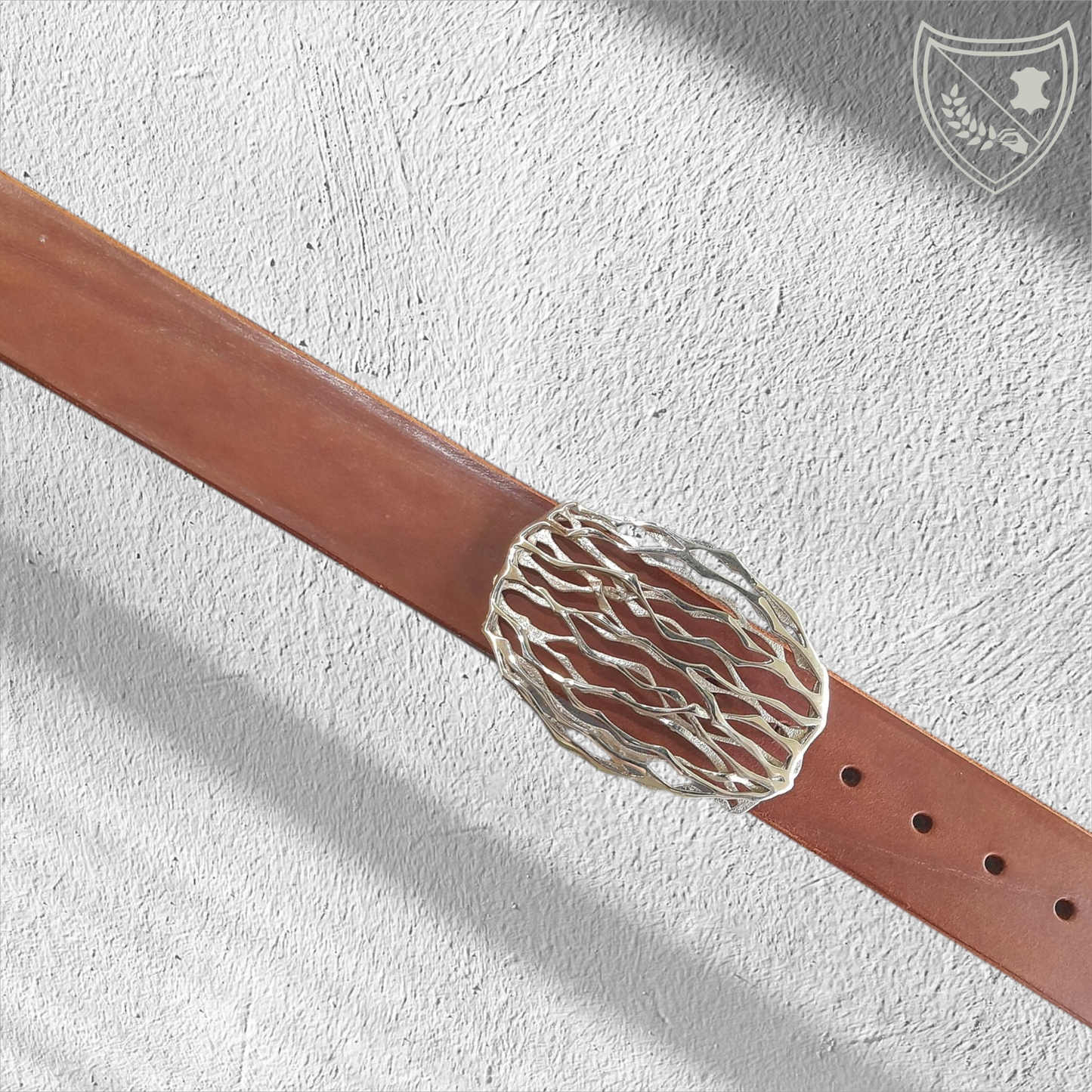 Ceinture cuir tannage végétal couleur havana avec boucle de ceinture Wave, lignes ondoyantes organiques inspirées de la nature, allure fluide et singulière, pièce artistique moderne, fermoir fiable pour confort et maintien. Vue de face 