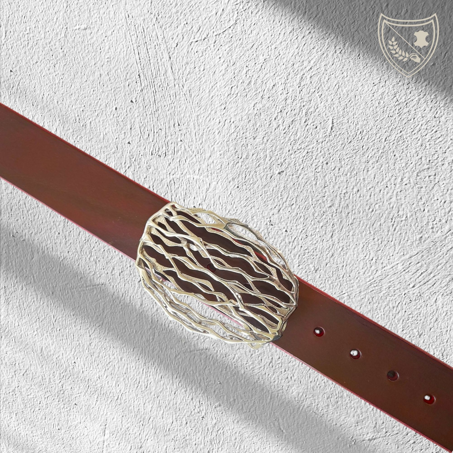 Ceinture cuir tannage végétal couleur victoria avec boucle de ceinture Wave, lignes ondoyantes organiques inspirées de la nature, allure fluide et singulière, pièce artistique moderne, fermoir fiable pour confort et maintien. Vue de face 