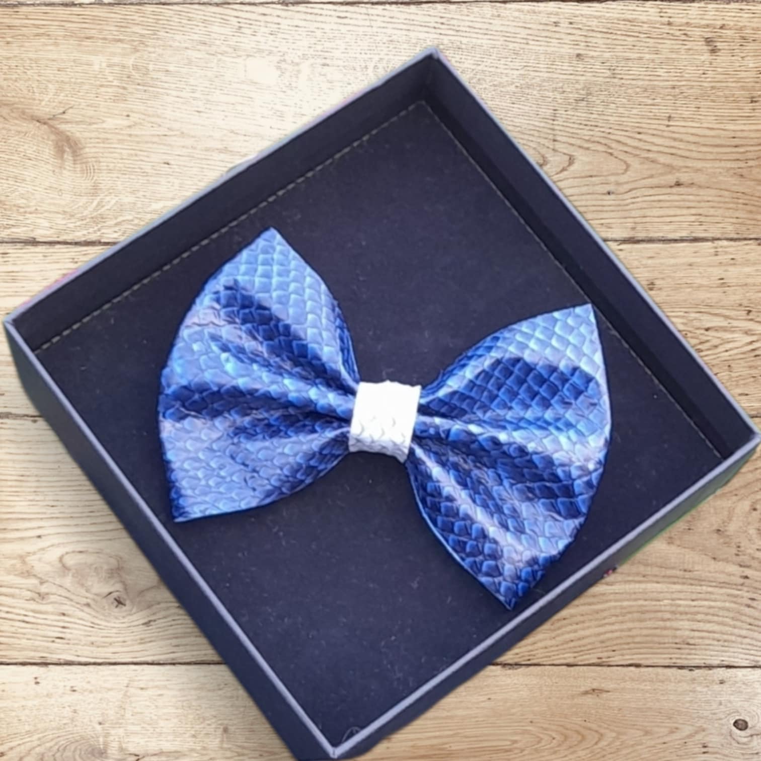 boite en carton de qualité, présentant un noeud papillon dégradé entre bleu indigo et bleu marine.