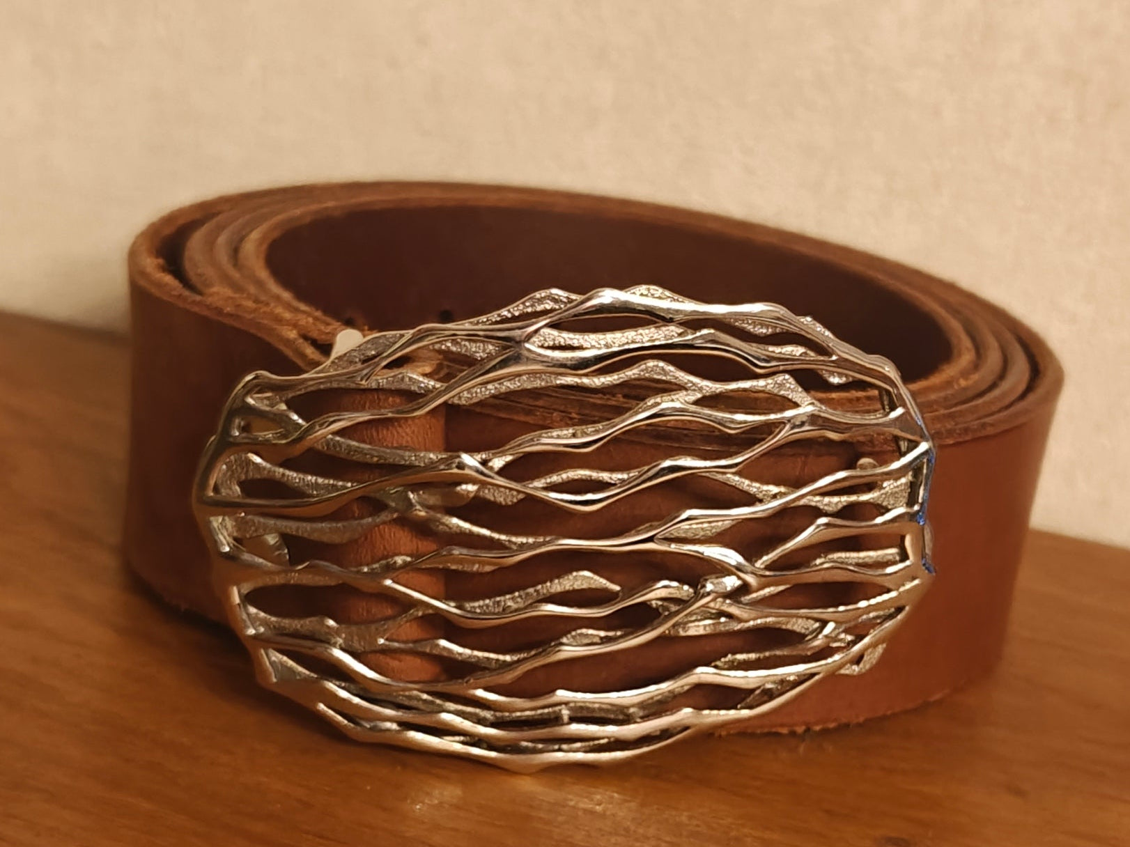 ceinture epicuirienne brune  sur table en bois 