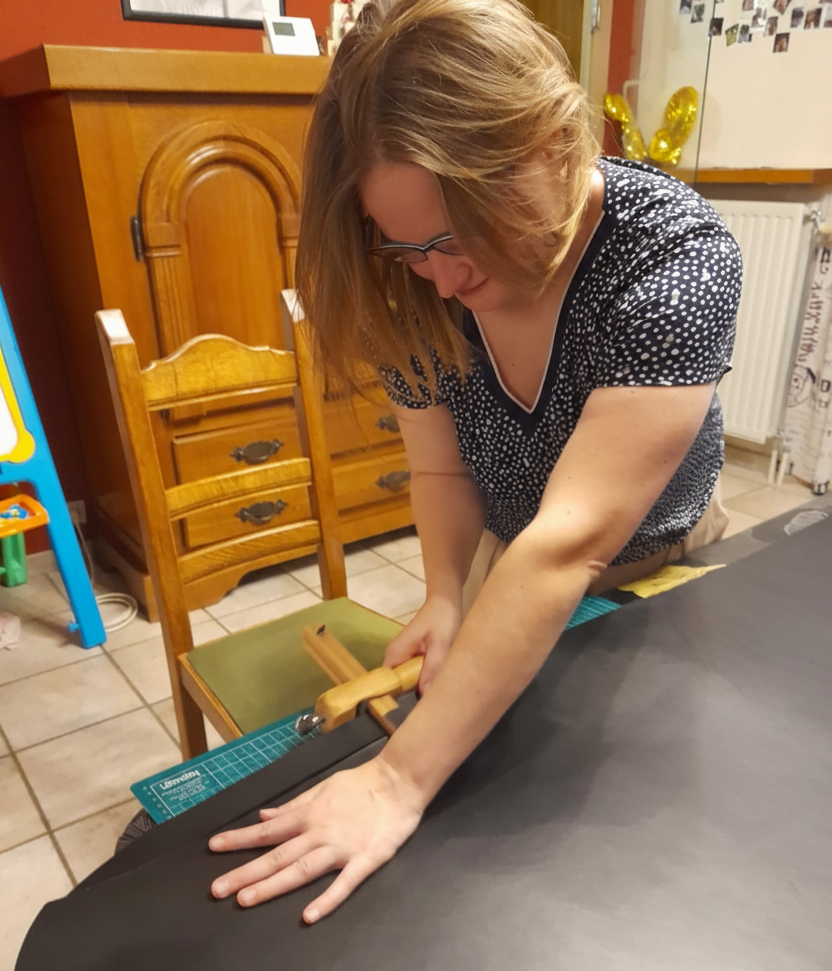 Epicuirienne au travail - découpe d'une bande de cuir pour la création d'une ceinure dans son salon